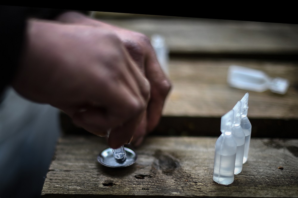 A drug addict prepares cocaine for injection in a small wooded area used by addicts to take drugs near Glasgow city centre, Scotland August 15, 2019. u00e2u20acu201d AFP pic        