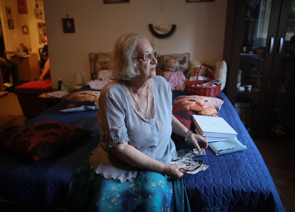 Serbian citizen Ester Bajer, who was born in a former Nazi camp, known as ‘Staro Sajmiste’ looks at photographs as she sits on her bed in Belgrade August 23, 2019. — AFP pic       