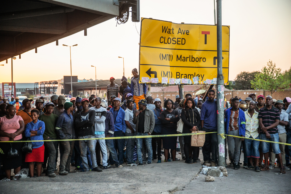 Residents of Johannesburgu00e2u20acu2122s Alexandra stand behind a police cordon as they gather at the scene where a body of a burned person was found inside a looted shop September 04, 2019. u00e2u20acu201d AFP pic