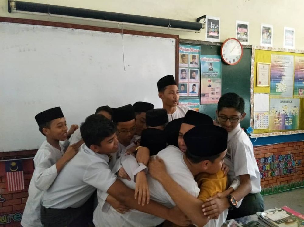 Safwan and his students share an emotional group hug during his last day teaching at school. u00e2u20acu201d Picture from Twitter/awanjebat