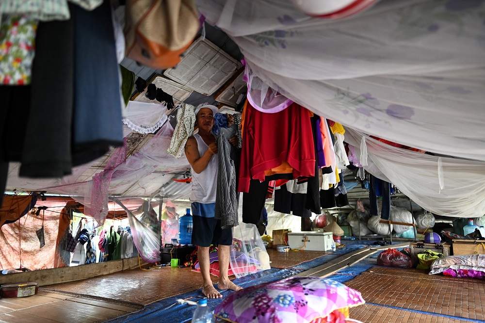 This photograph taken on September 7, 2019 shows Han Van Hoa, a Vietnamese migrant worker living for the past 10 years in a floating guesthouse along the banks of the Red River in Hanoi, hanging his clothes to dry after a day’s work. — AFP pic       