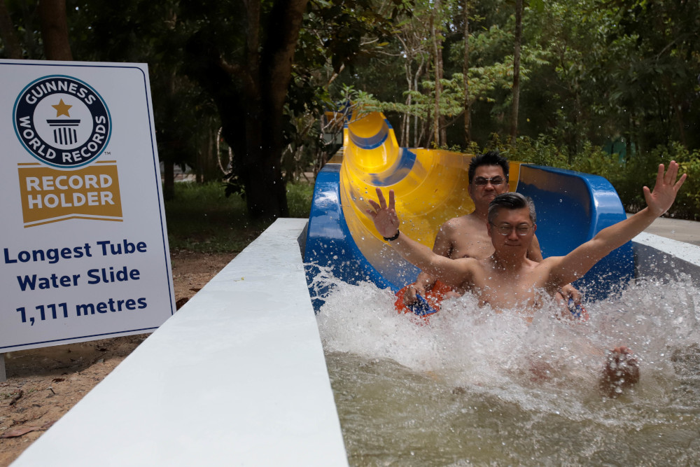 Sim Leisure Group Chief Executive Officer Sim Choo Kheng (back), slides down on a floater on the world’s longest water slide at Escape theme park in Teluk Bahang, Malaysia September 25, 2019. — AFP pic 