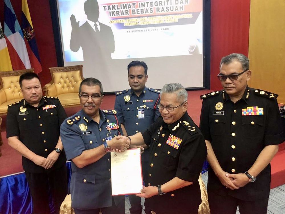 Johor Fire and Rescue Department director Datuk Yahaya Madis (second from left) and MACC director Datuk Norazlan Mohd Razali shake hands in Johor Baru September 11, 2019. u00e2u20acu201d Picture by Ben Tan