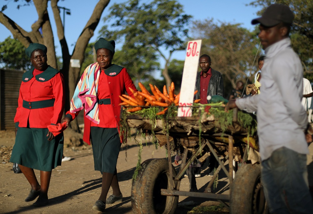 Women wearing church regalia walk past a vegetable vendor in Mbare township outside the capital Harare, Zimbabwe September 8, 2019. u00e2u20acu201d Reuters pic 