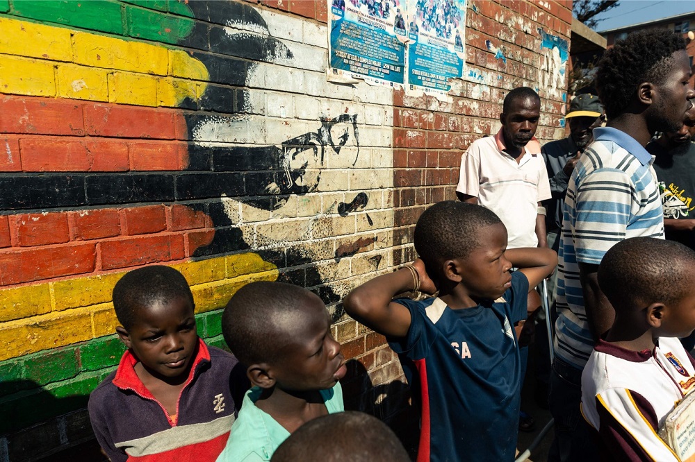 Children stand beside a mural of former Zimbabwe President Robert Mugabe in Mbare district of Harare September 6, 2019. u00e2u20acu201d AFP pic