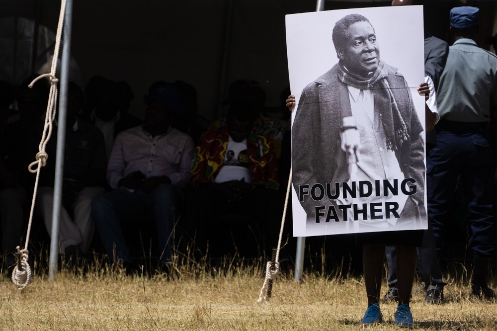 A man holds a placard reading u00e2u20acu02dcFounding Fatheru00e2u20acu2122 as the coffin of late former Zimbabwean president Robert Mugabe arrives at Murombedzi Growth Point, Zimbabwe, on September 16, 2019. u00e2u20acu201d AFP pic            