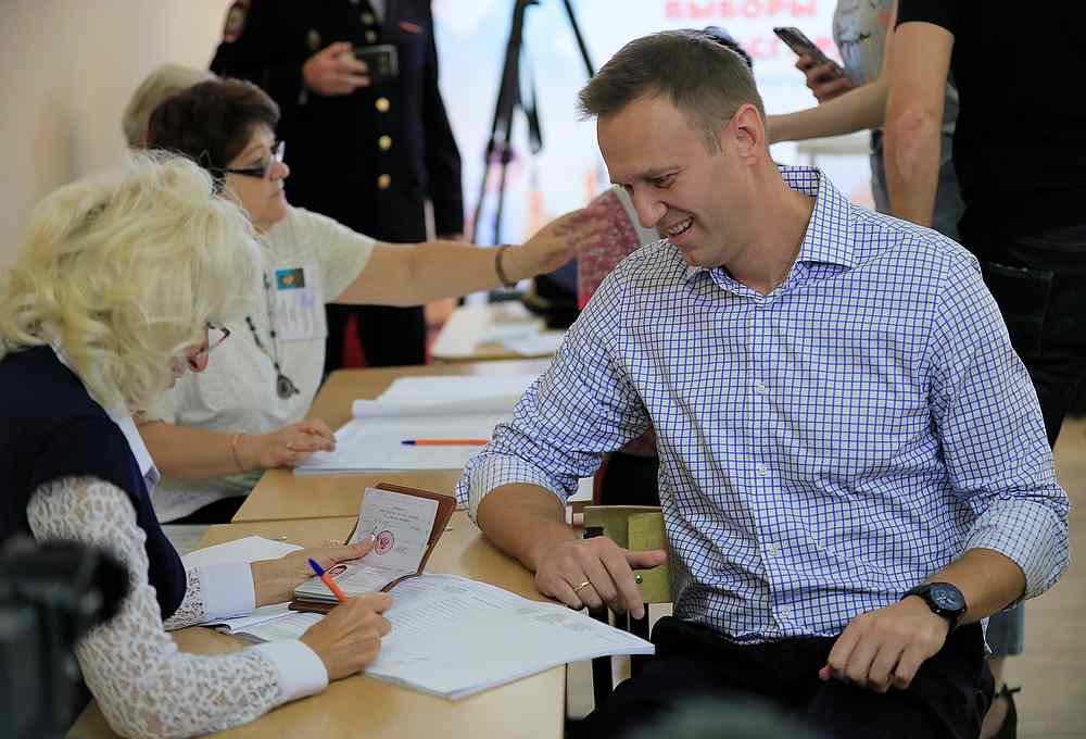 Russian opposition leader Alexei Navalny sits in front of members of a local electoral commission at a polling station during the Moscow city parliament election September 8, 2019. u00e2u20acu201d Reuters pic
