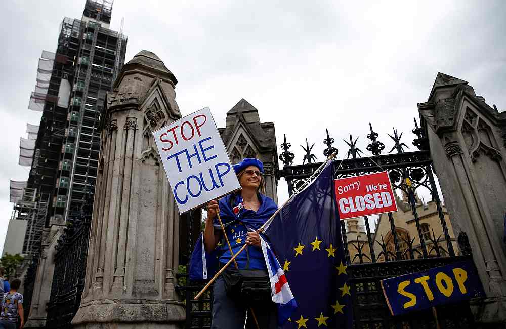 A protester holds signs during an anti-Brexit protest in Westminster, London August 31, 2019. u00e2u20acu201d Reuters pic