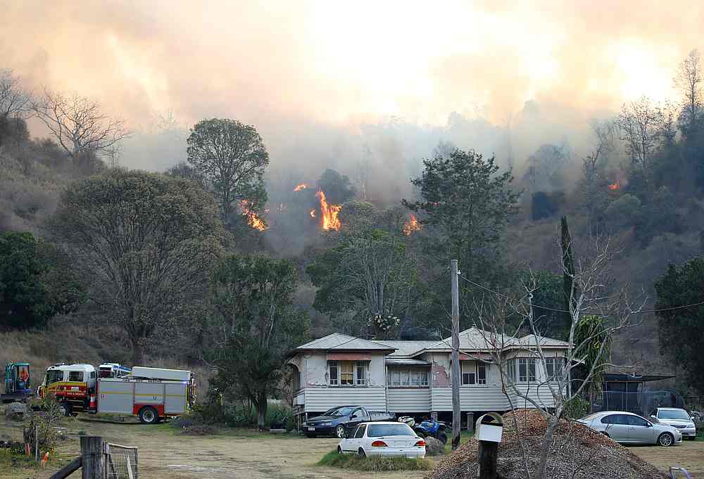 Fire and Emergency crew battle a bushfire near a house in Canungra, Queensland, Australia September 6, 2019. u00e2u20acu201d Regi Varghese/AAP pic via Reuters