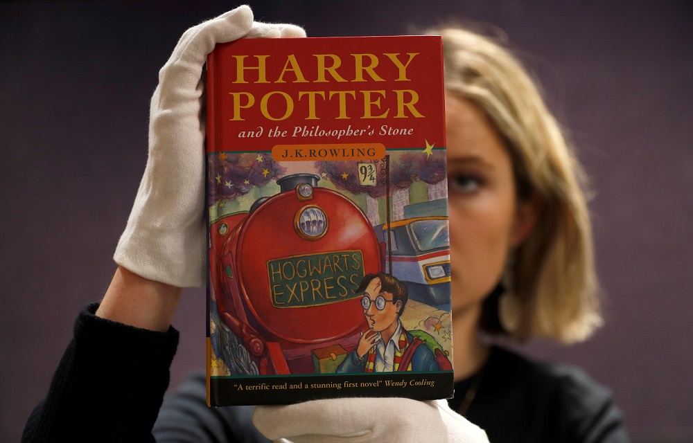 One of the first ever copies of u00e2u20acu02dcHarry Potter and the Philosopheru00e2u20acu2122s Stoneu00e2u20acu2122 by J.K. Rowling, is held by a staff at Bonhams auctioneers, ahead the Fine Books, Manuscripts, Atlases and Historical Photographs sale in London March 27, 2019. u00e2u20acu201d Reuters p