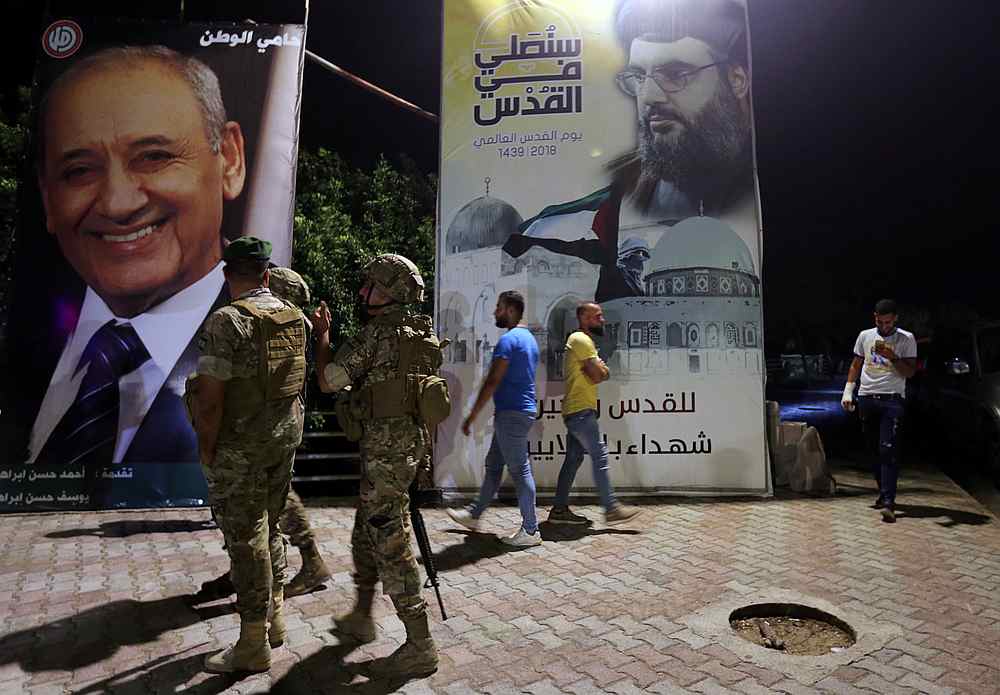 Lebanese army soldiers stand near a poster of Lebanon's Hezbollah leader Sayyed Hassan Nasrallah in Adaisseh village near the Lebanese-Israeli border, Lebanon August 28, 2019. u00e2u20acu201d Reuters pic