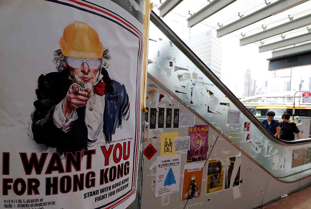 People take an escalator next to posters and sticker notes supporting the anti-government protest movement near the Central Government Offices in Hong Kong September 5, 2019. — Reuters pic