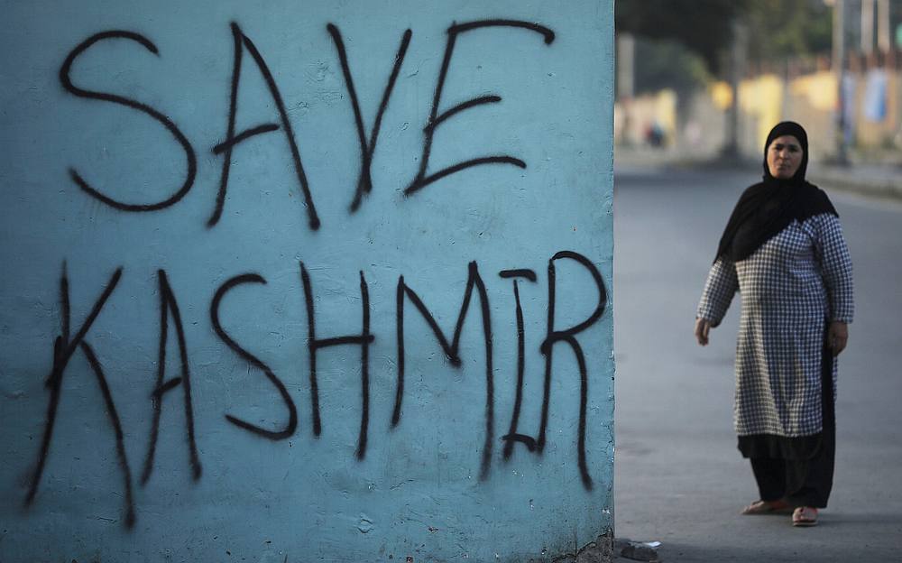 A Kashmiri woman stands next to a graffiti written on a wall during restrictions by the Indian government in Srinagar September 15, 2019. u00e2u20acu201d Reuters pic 