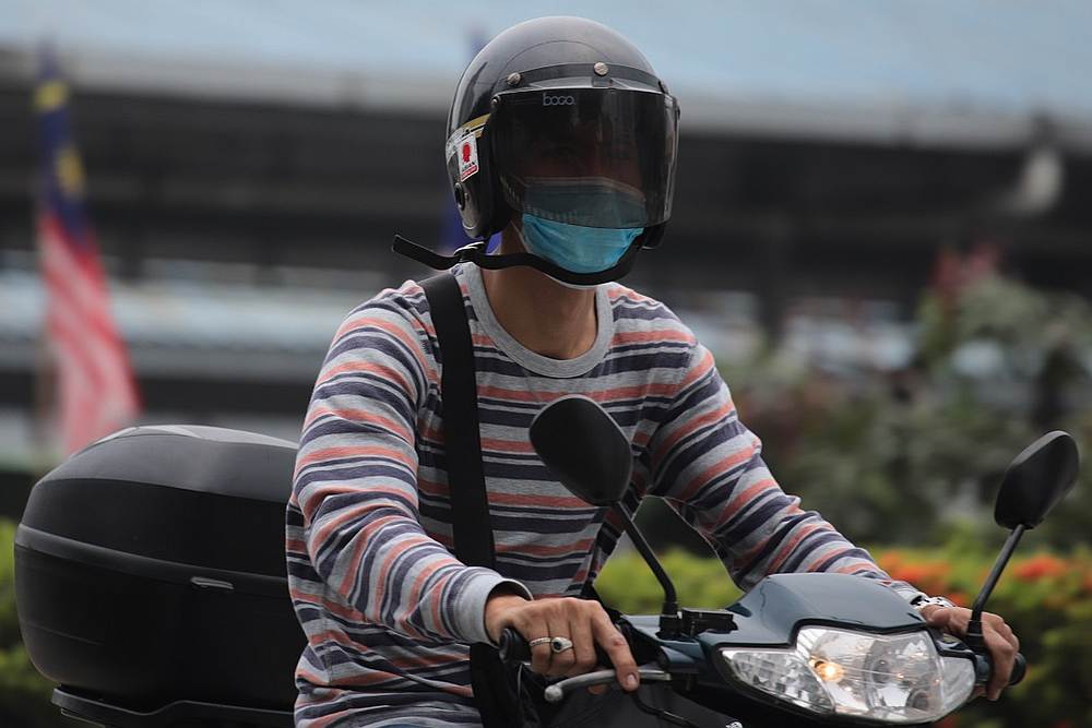 A motorcyclist wears a mask as haze blankets Kuala Lumpur September 18, 2019. u00e2u20acu201d AFP pic