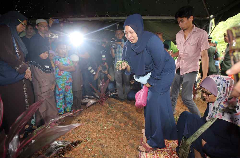 Mohd Zahir’s widow Nour Shafinar Harun during the burial ceremony at the Tanah Perkuburan Islam Tambun in Ipoh.