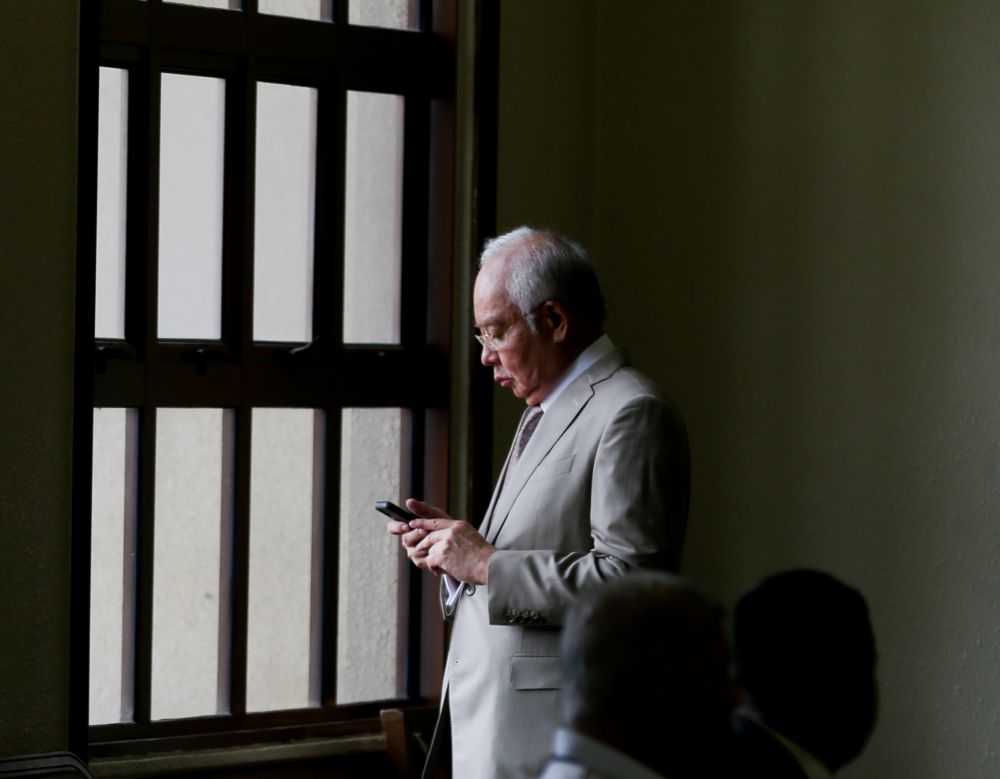 Datuk Seri Najib Razak checks his phone at the Kuala Lumpur High Court September 3, 2019.  u00e2u20acu201d Picture by Firdaus Latif