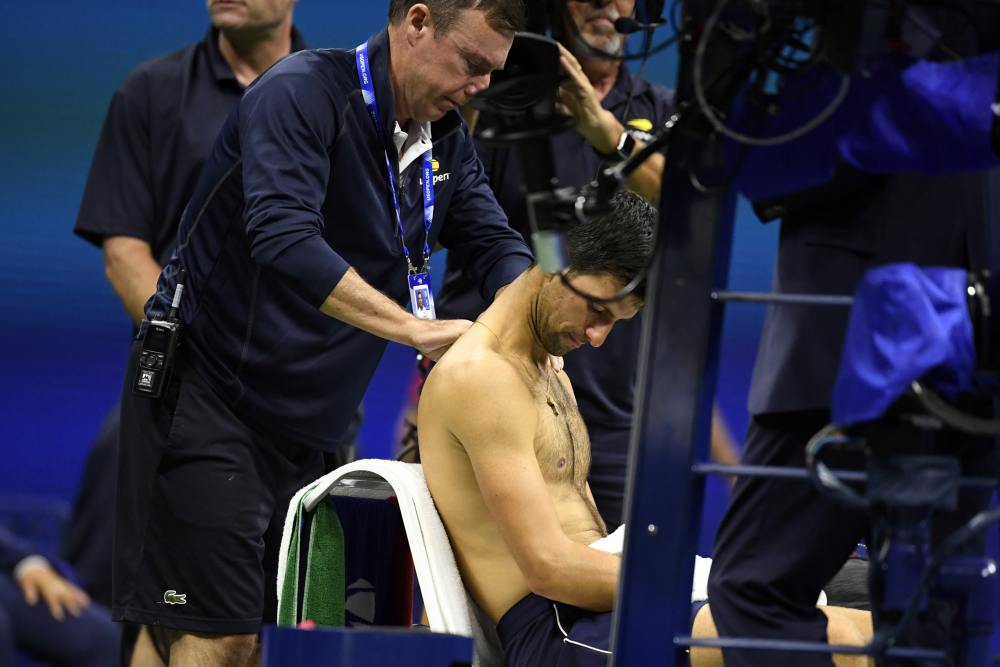 Novak Djokovic has his shoulder worked on by an athletic trainer during a match against Stan Wawrinka in the fourth round on day seven of the 2019 US Open tennis tournament, September 2, 2019. u00e2u20acu2022 Picture by Danielle Parhizkaran-USA TODAY Sports via Reute