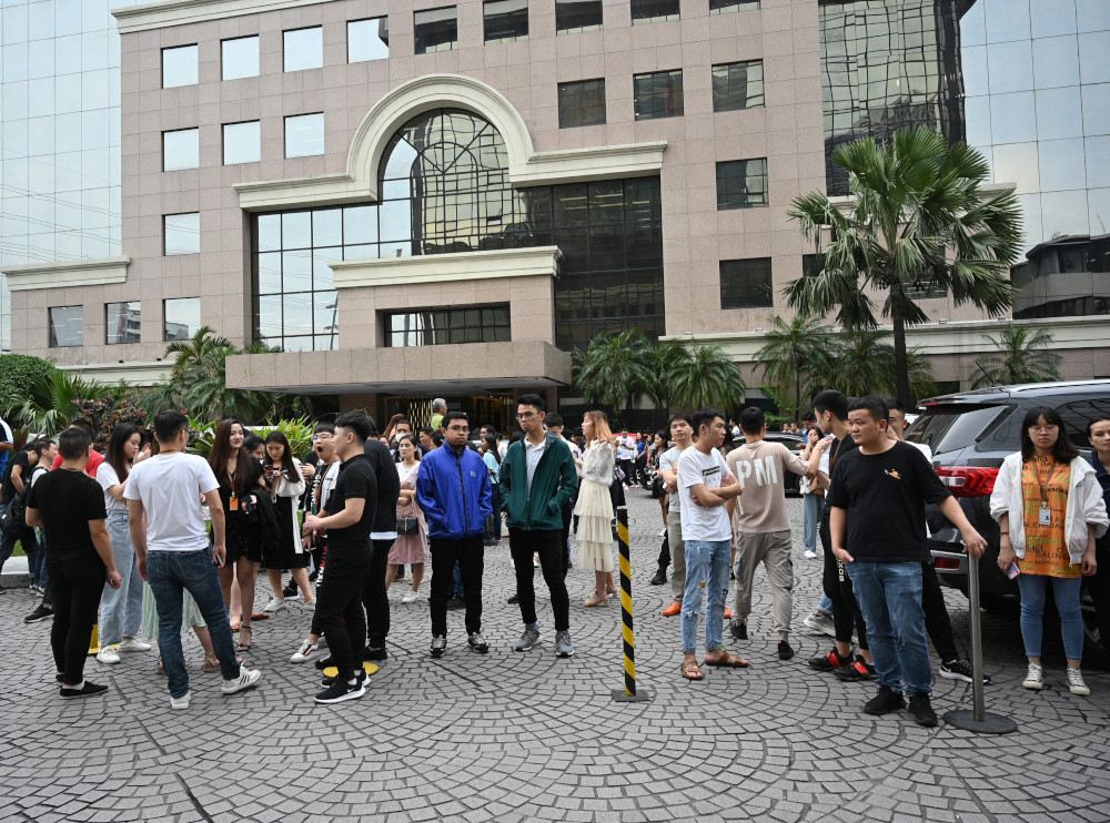 Office workers stand outside their building after a 5.2-magnitude hit Manila September 13, 2019. u00e2u20acu201d AFP pic 