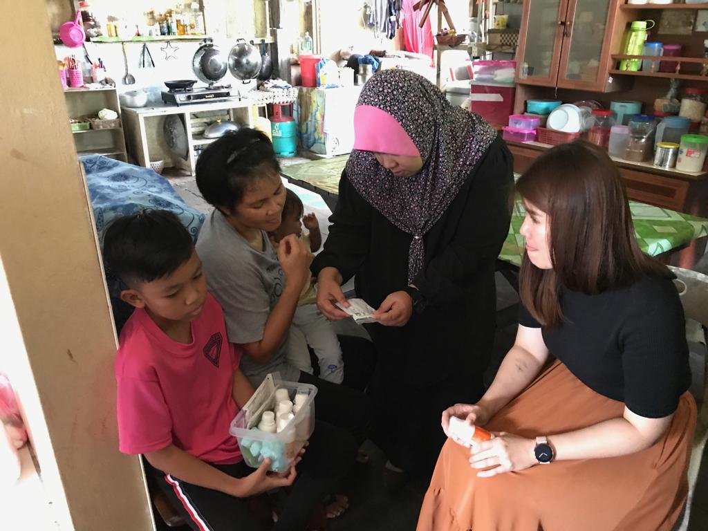 Wong (right) and Zarina looking through the pile of medication that 12-year-old nose cancer patient Cyle Addel takes. — Picture courtesy of The Malaysian AIDS Foundation