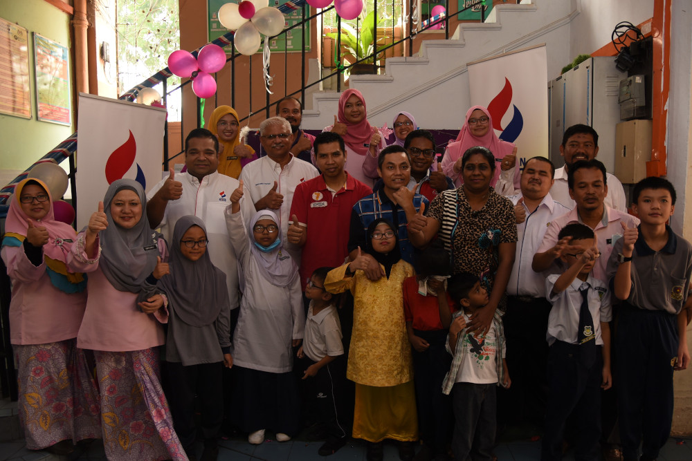 Trustees from Yayasan MRCB pose for a picture with teachers, parents and students at Sekolah Kebangsaan Pendidikan Khas Jalan Batu in KL during the handover ceremony. u00e2u20acu201d Picture courtesy of Yayasan MRCB