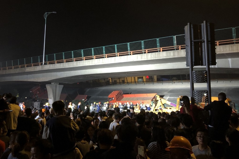 This photo shows a crowd watching workers at the site of a highway overpass collapse in Wuxi, Chinau00e2u20acu2122s eastern Jiangsu province October 10, 2019. u00e2u20acu201d Picture by STR via AFP