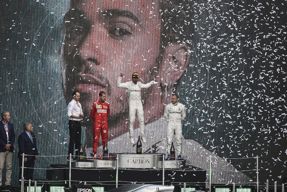 Mercedesu00e2u20acu2122 Lewis Hamilton celebrates on the podium after winning the F1 Mexico Grand Prix, next to runner-up Ferrariu00e2u20acu2122s Sebastian Vettel and third-place Mercedesu00e2u20acu2122 Valtteri Bottas in Mexico City October 27, 2019. u00e2u20acu201d AFP pic