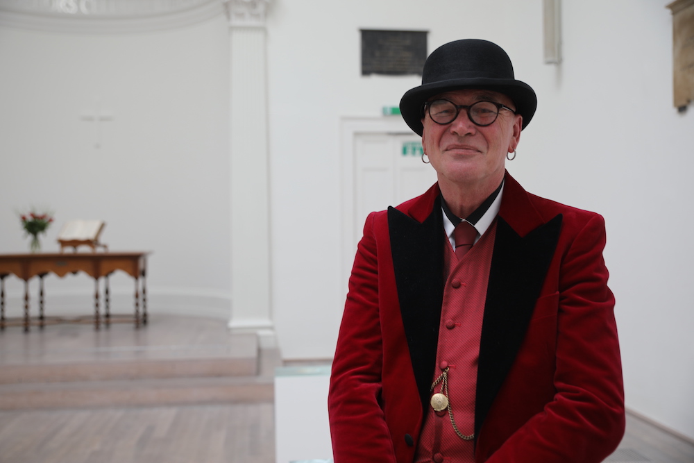 Homeless artist Andy Palfreyman poses at his photographic work at the opening of his exhibition at the Swiss Church in London October 3, 2019. u00e2u20acu201d Thomson Reuters Foundation/Adela Suliman pic