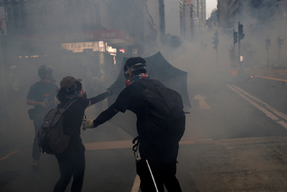 Protesters take cover from a cloud of tear gas during an anti-government rally in central Hong Kong October 6, 2019. u00e2u20acu201d Reuters pic