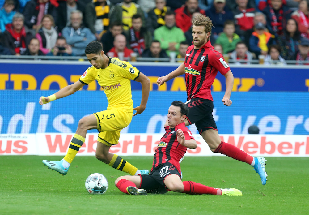 Borussia Dortmundu00e2u20acu2122s Achraf Hakimi in action with SC Freiburgu00e2u20acu2122s Nicolas Hofler during their Bundesliga match at Schwarzwald-Stadion in Freiburg October 5, 2019. u00e2u20acu201d Reuters pic