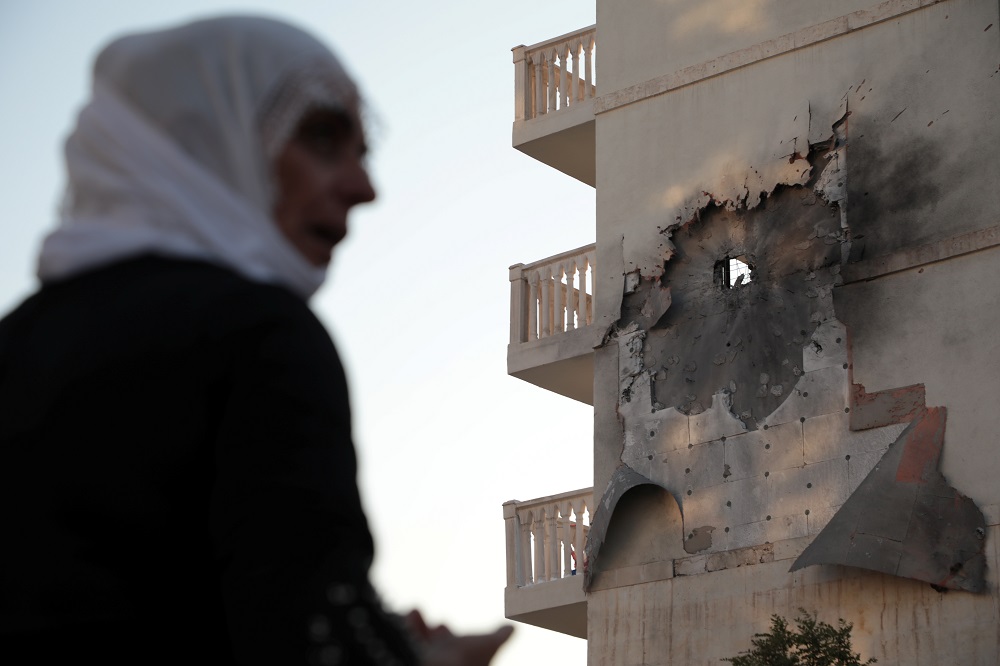 A woman stands in front of an apartment building which was damaged by a rocket fired from Syria, in Nusaybin, Turkey October 10, 2019. u00e2u20acu201d Reuters pic