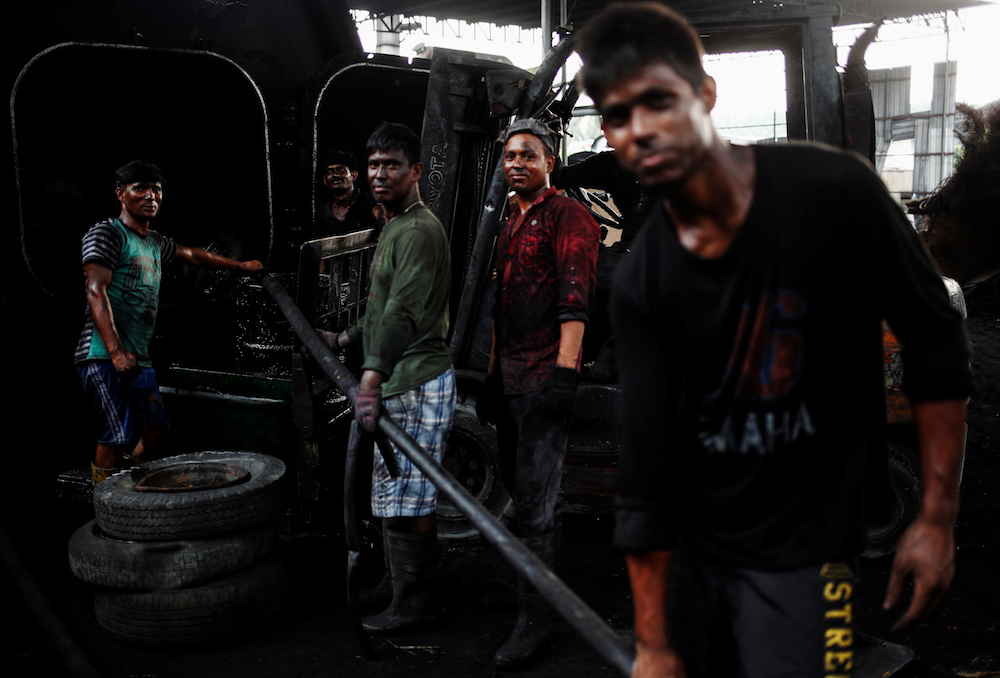 Bangladeshi workers react to the camera as they work at a tyre pyrolysis plant in Kulai, Johor August 7, 2019. — Reuters pic