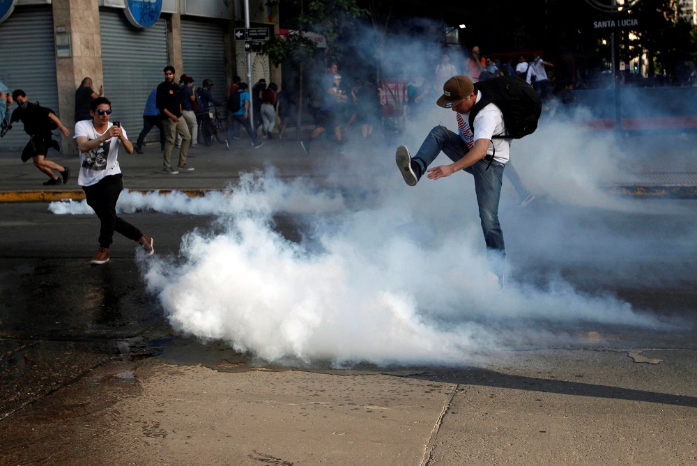 A demonstrator kicks a tear gas canister during a protest against the increase in the subway ticket prices in Santiago October 18, 2019. u00e2u20acu201d Reuters pic