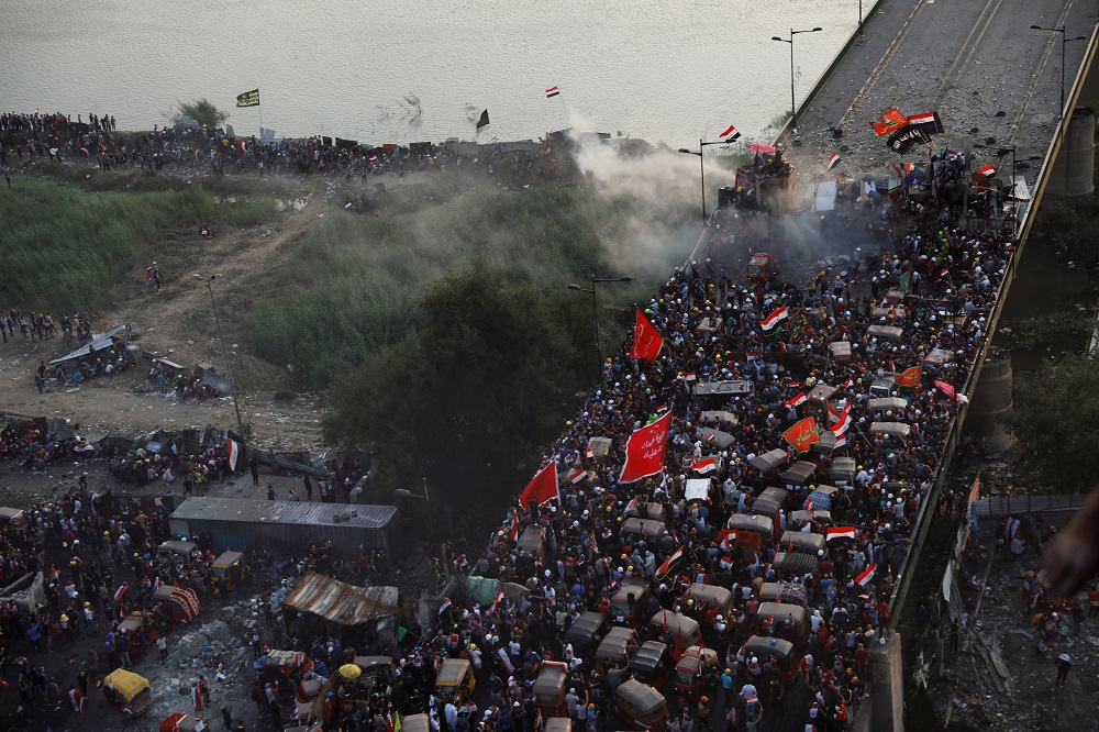 Demonstrators take cover as Iraqi security forces fired tear gas at Al Jumhuriya bridge during an anti-government protests in Baghdad October 30, 2019. u00e2u20acu201d Reuters pic