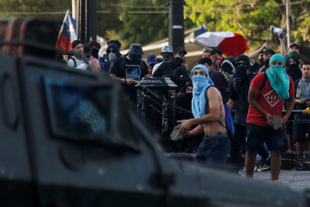 Demonstrators throw stones at a police vehicle during an anti-government protest in Santiago October 30, 2019. u00e2u20acu201d Reuters pic