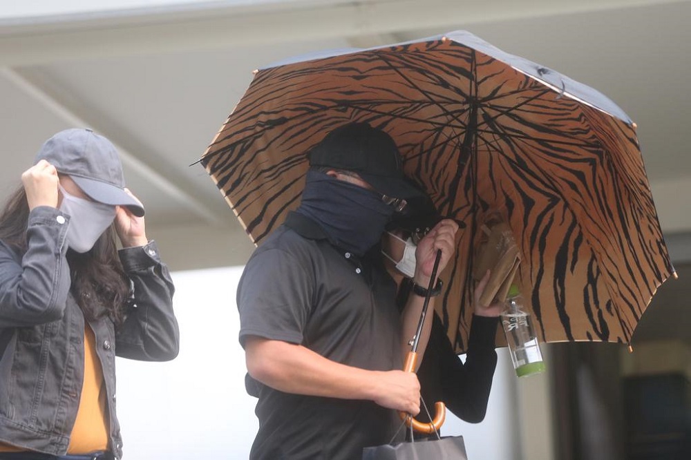 Stanley Cheng Kim Han, 44, (centre, holding umbrella) leaving the State Courts on September 11, 2019. Cheng was convicted of two counts of outraging the modesty of his maid while they were alone in his flat. u00e2u20acu201d TODAY pic