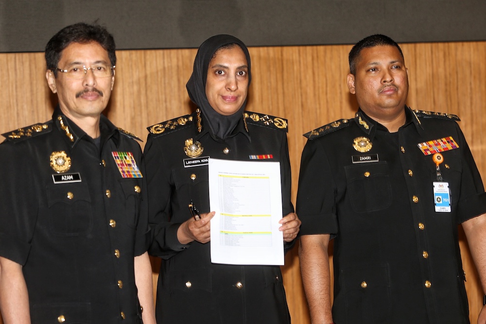 (From left) Datuk Seri Azam Baki, Latheefa Koya and Mohamad Zamri Zainul Abidin pose for pictures with a list of those who will receive compound notices related to 1MDB funds during a press conference in Putrajaya October 7, 2019. u00e2u20acu201d Picture by Choo Choy