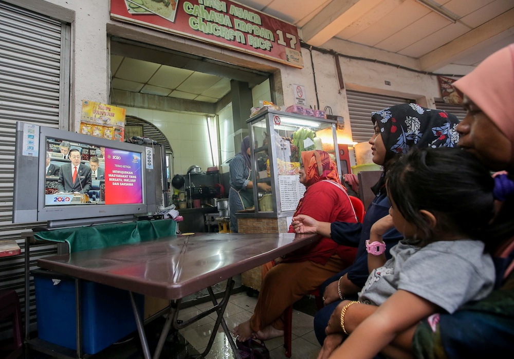 People watch the Budget 2020 speech by Finance Minister Lim Guan Eng u00e2u20acu02dcliveu00e2u20acu2122 at a restaurant in Medan Selera Medan Kidd in Ipoh October 11, 2019. u00e2u20acu201d Picture by Farhan Najib