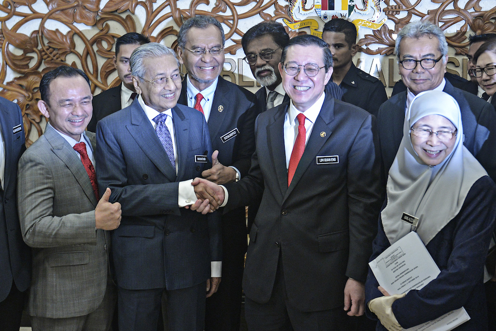 Prime Minister Tun Dr Mahathir Mohamad shakes hands with Finance Minister Lim Guan Eng in Parliament October 11, 2019, after the tabling of Budget 2020. u00e2u20acu201d Picture by Shafwan Zaidon