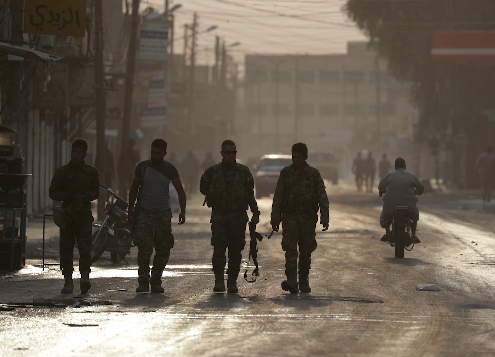 Turkey-backed Syrian rebel fighters walk together in the border town of Tal Abyad, Syria, October 15, 2019. u00e2u20acu201d Reuters pic