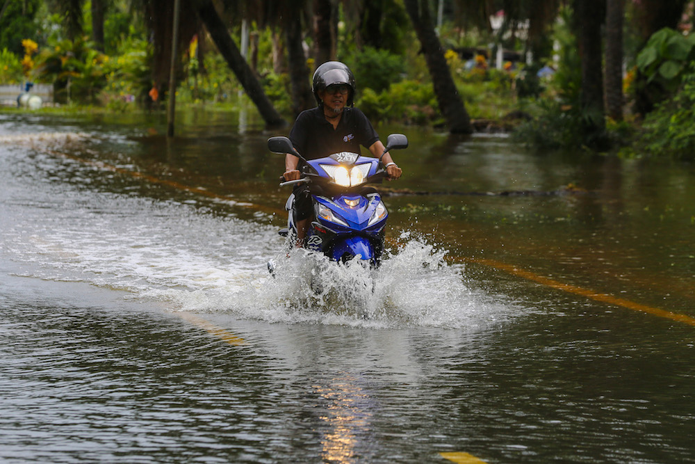 A motorist navigates a flooded road in Kampung Parit Mahang, Jeram October 28, 2019. u00e2u20acu201d Picture by Yusof Mat Isa