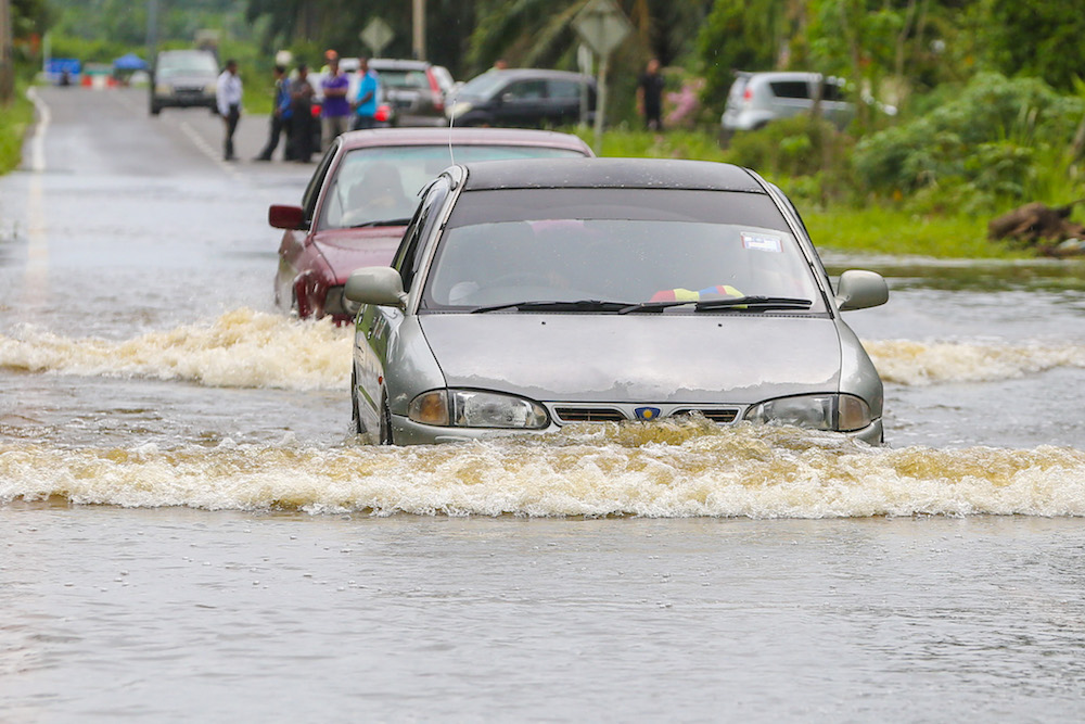 Motorists navigate a flooded road in Kampung Parit Mahang, Jeram October 28, 2019. — Picture by Yusof Mat Isa