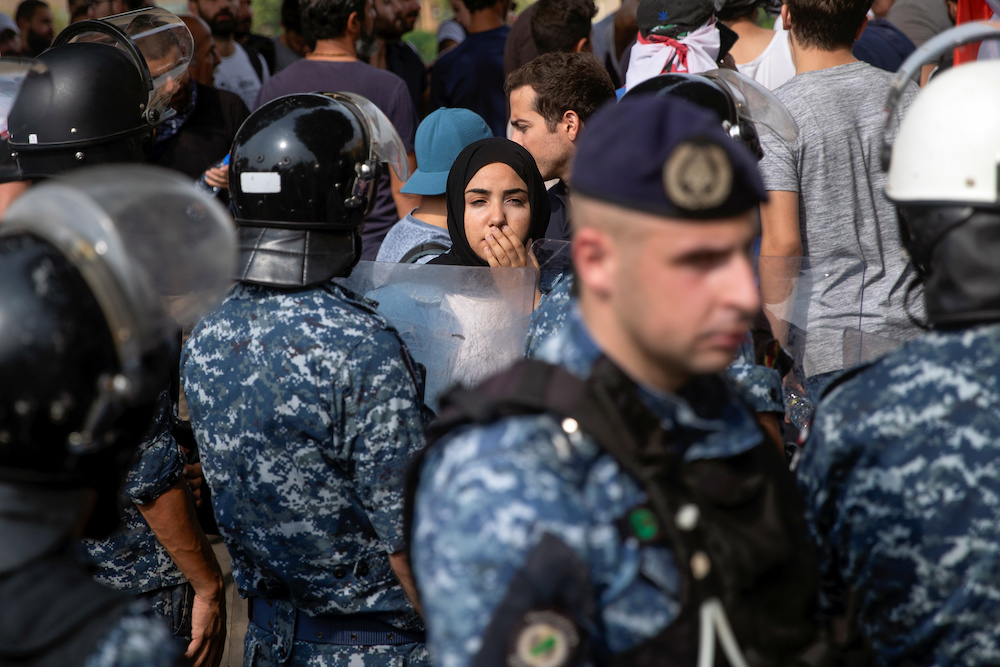 A demonstrator stands next to a riot police cordon, following a police operation to open a blocked highway during ongoing anti-government protests in downtown Beirut October 26, 2019. u00e2u20acu201d Reuters pic