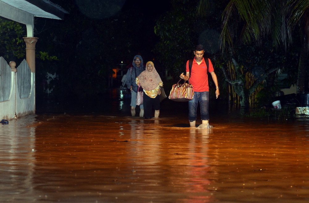 Local residents walk through flood waters following a heavy downpour in Kampung Permatan Rawa in Bukit Mertajam October 27, 2019. u00e2u20acu201d Bernama pic