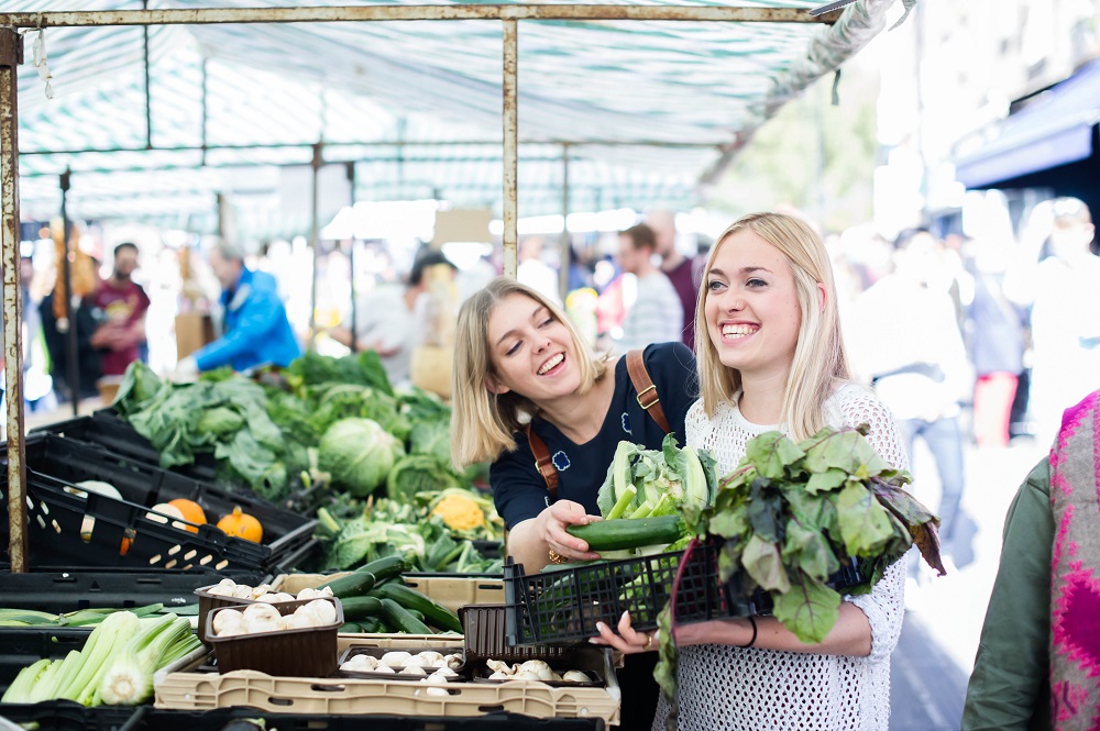 Sisters Eccie and Gini Newton, owners of u00e2u20acu02dcKarma Kithchenu00e2u20acu2122 collect vegetables in a market in London. u00e2u20acu2022 Picture courtesy of Karma Co- Kitchen Ltd