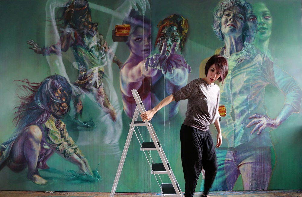 Artist Sara Shamma stands in front of an artwork in her u00e2u20acu02dcModern Slaveryu00e2u20acu2122 exhibition inspired by interviews with female trafficking survivors in an undated handout photograph courtesy of Sara Shamma. u00e2u20acu201d Reuters pic