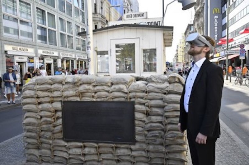 Jonas Rothe, founder and CEO of Timeride, a company offering Virtual Reality tours through a still-divided Berlin, poses next to Checkpoint Charlie. u00e2u20acu201d AFP-Relaxnews picnn