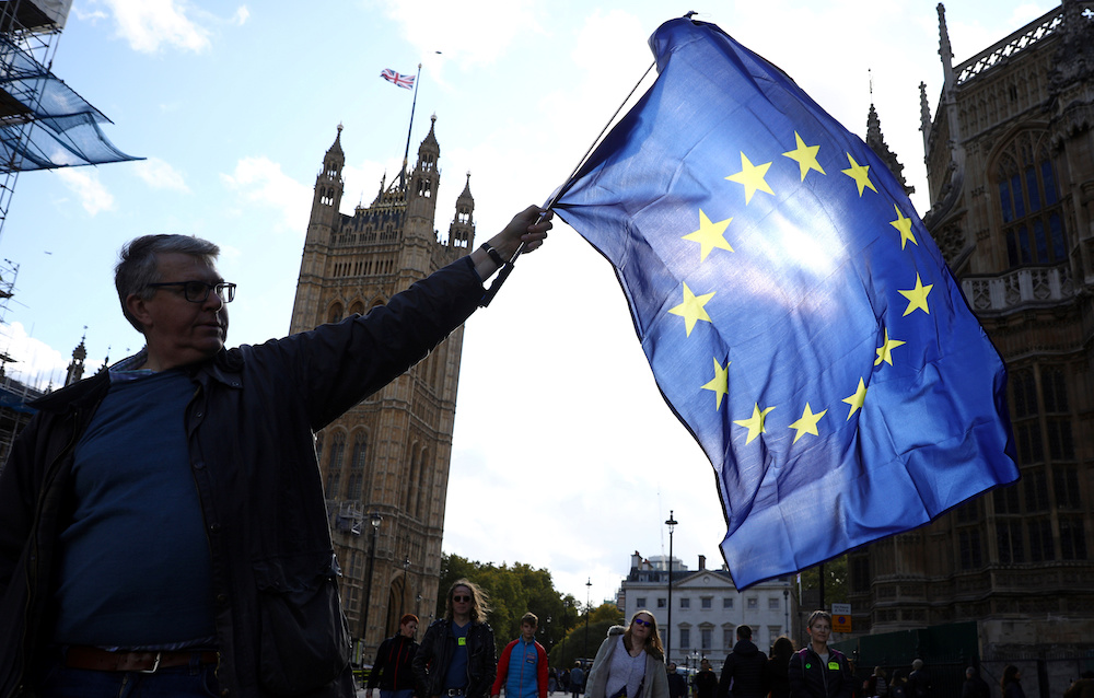 A EU supporter waves a flag while other demonstrators march as parliament sits on a Saturday for the first time since the 1982 Falklands War, to discuss Brexit in London, Britain, October 19, 2019. u00e2u20acu201d Reuters pic