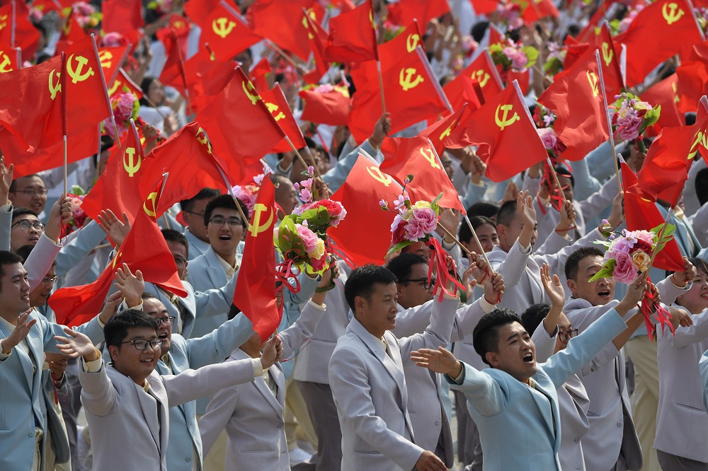 People wave Communist Party flags during a military parade in Tiananmen Square in Beijing on October 1, 2019, to mark the 70th anniversary of the founding of the People's Republic of China. u00e2u20acu201d AFP pic  