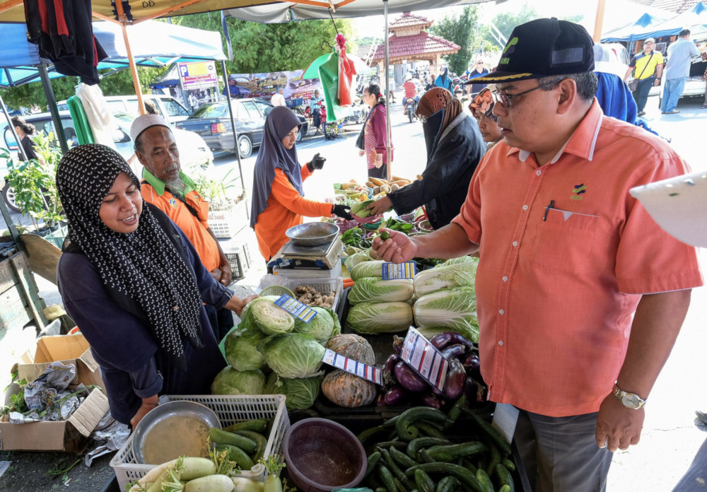 Fama director-general Zainal Abidin Yang Razalli speaks to a vegetable trader at the Kuala Kangsar farmeru00e2u20acu2122s market October 26, 2019. u00e2u20acu201d Bernama pic 