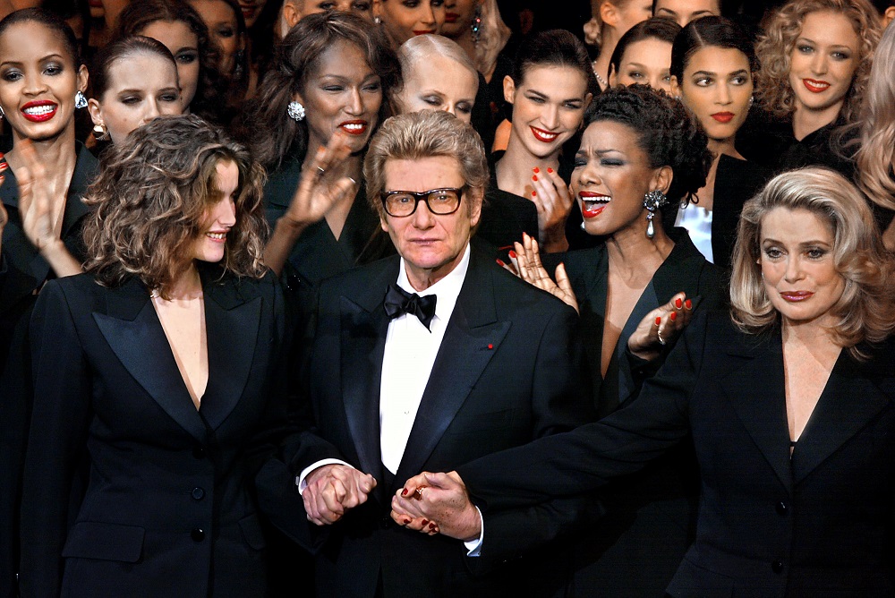 In this photo taken January 22, 2002, French fashion designer Yves Saint-Laurent salutes the crowd with French model Laetitia Casta (left) and French actress Catherine Deneuve during his last fashion show. u00e2u20acu201d AFP pic  